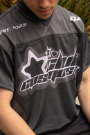 Close up shot of a model wearing a black and grey sports jersey with y2k graphics.