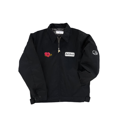 Black utility jacket with an embroidered patch and heart and star graphic on a white background.