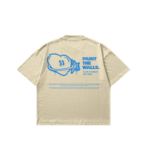 Beige shirt with blue club cosmos spray painted logo graphic and text on the back against a white background