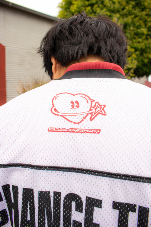 Model showcasing the back of a white sports jersey with 'Club Cosmo's' branding.