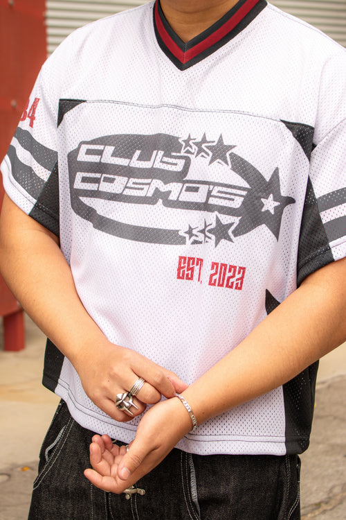 Person wearing a white sports jersey with 'Club Cosmos' branding.