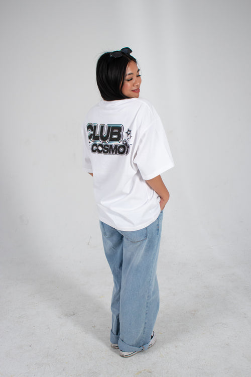 Model wearing a white t-shirt with 'CLUB COSMO'S' graphic text on the back, standing against a white background.