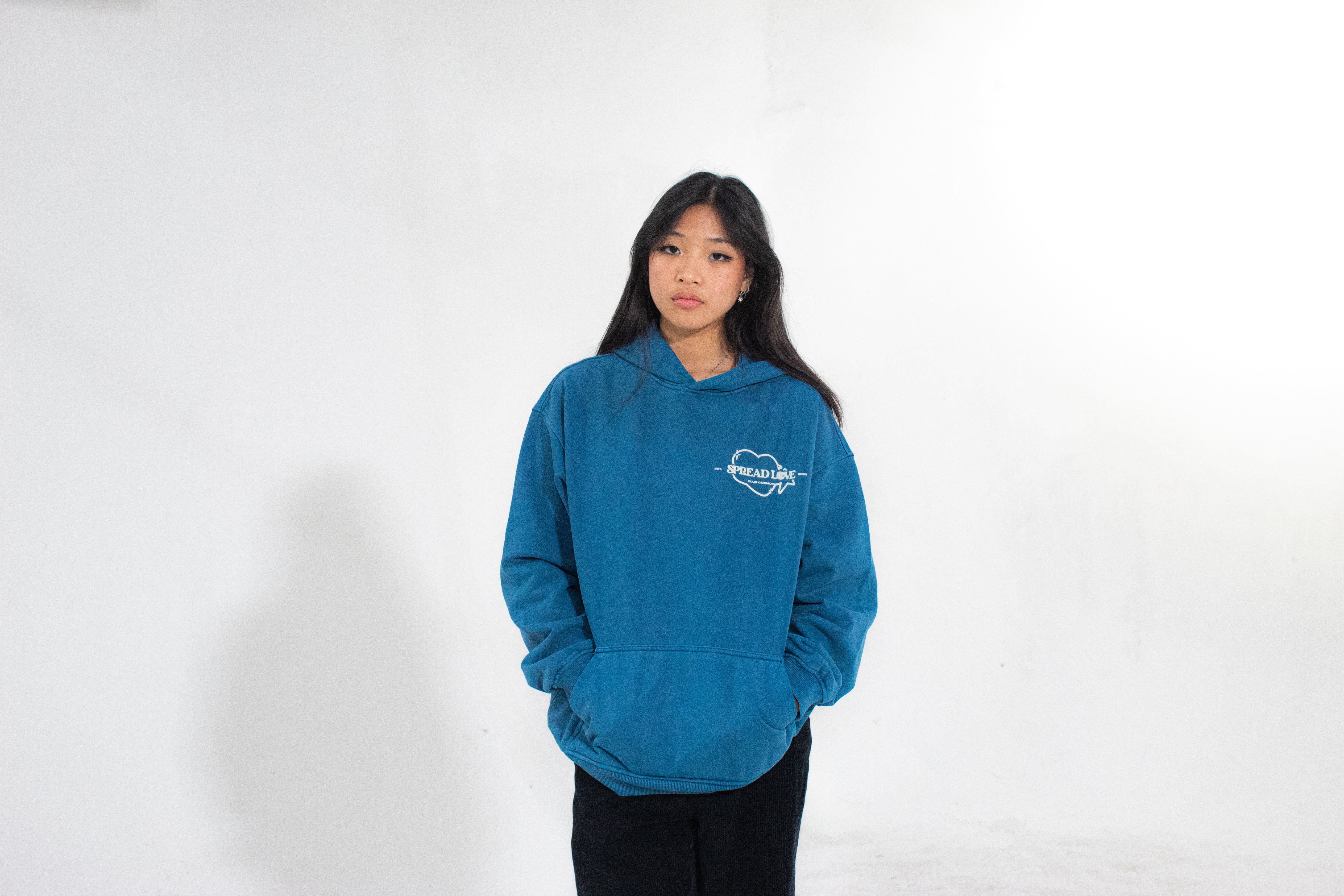 Model wearing a blue hoodie with a Club Cosmo's logo design on a white background.