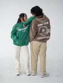 Two people wearing hoodies with visible Club Cosmo's branding on a white background.