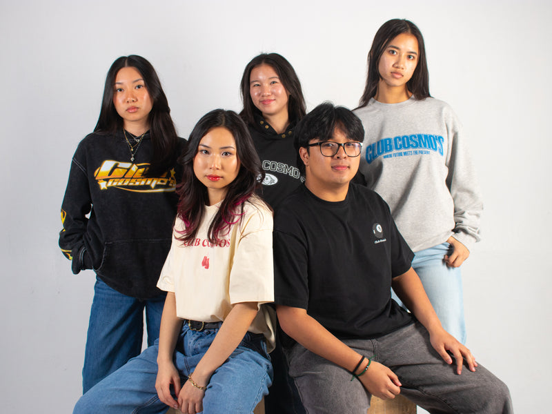 Five models wearing various Club Cosmo's apparel with different logos against a white background.