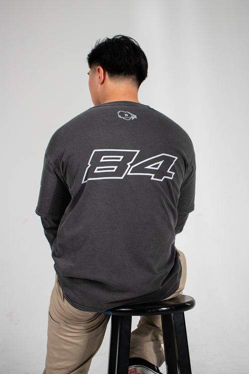 Model with their back turned showing off a grey Club Cosmo's long sleeve with the number 84 on it.