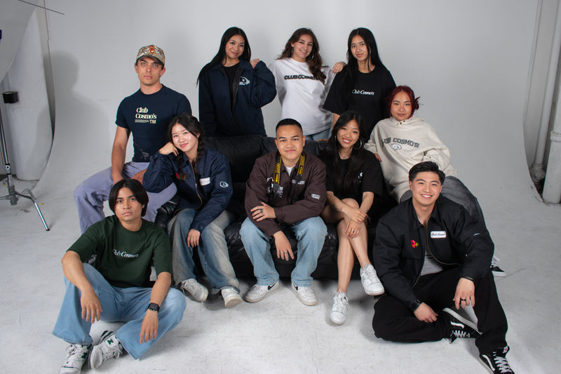 Group of Club Cosmo's team members posing together happily in a studio setting.