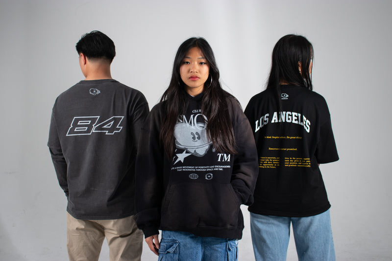 Three people wearing Club Cosmo's merchandise with visible text and graphics on a white background.