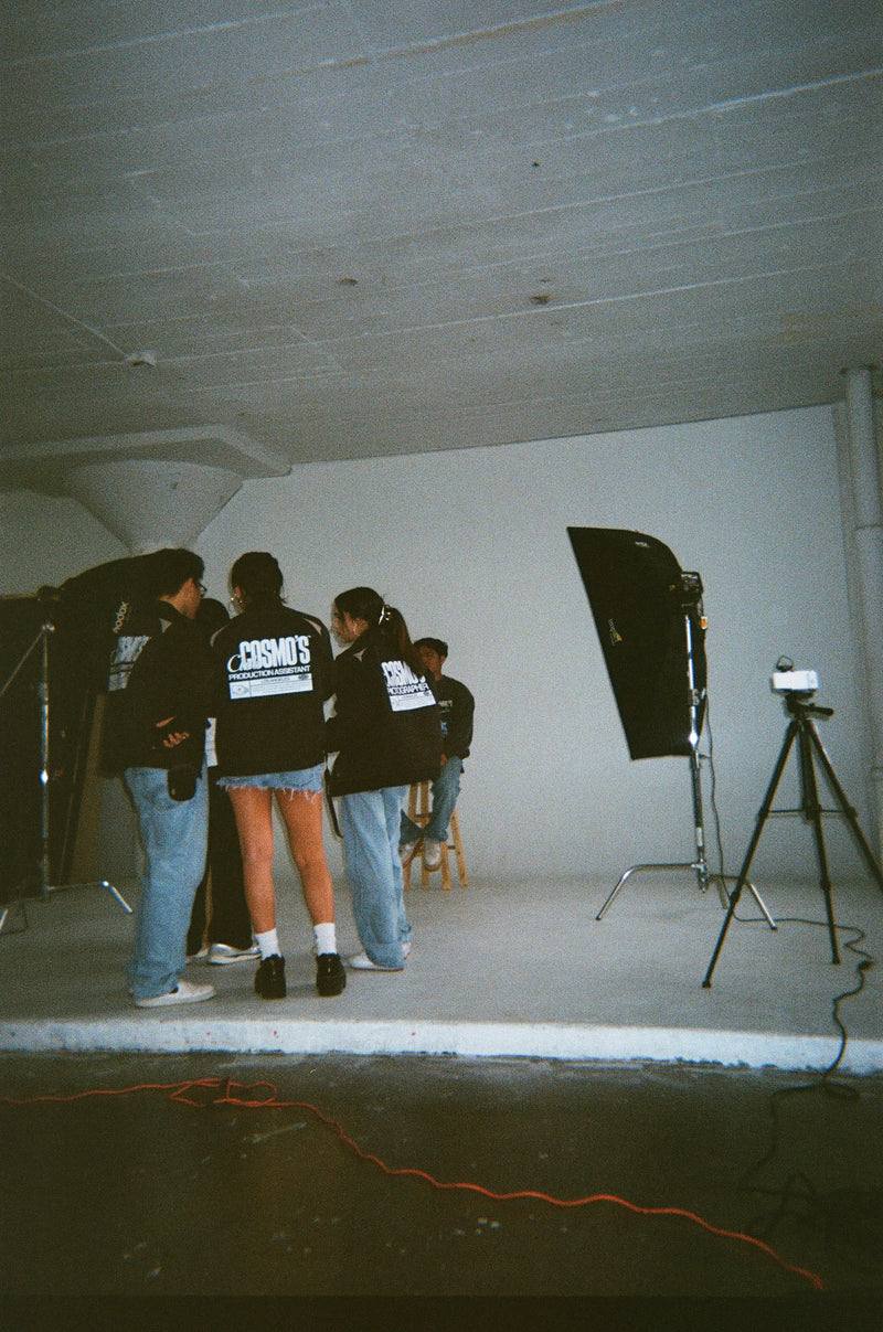 Group of Club Cosmo's team members in a studio setting with photography equipment.