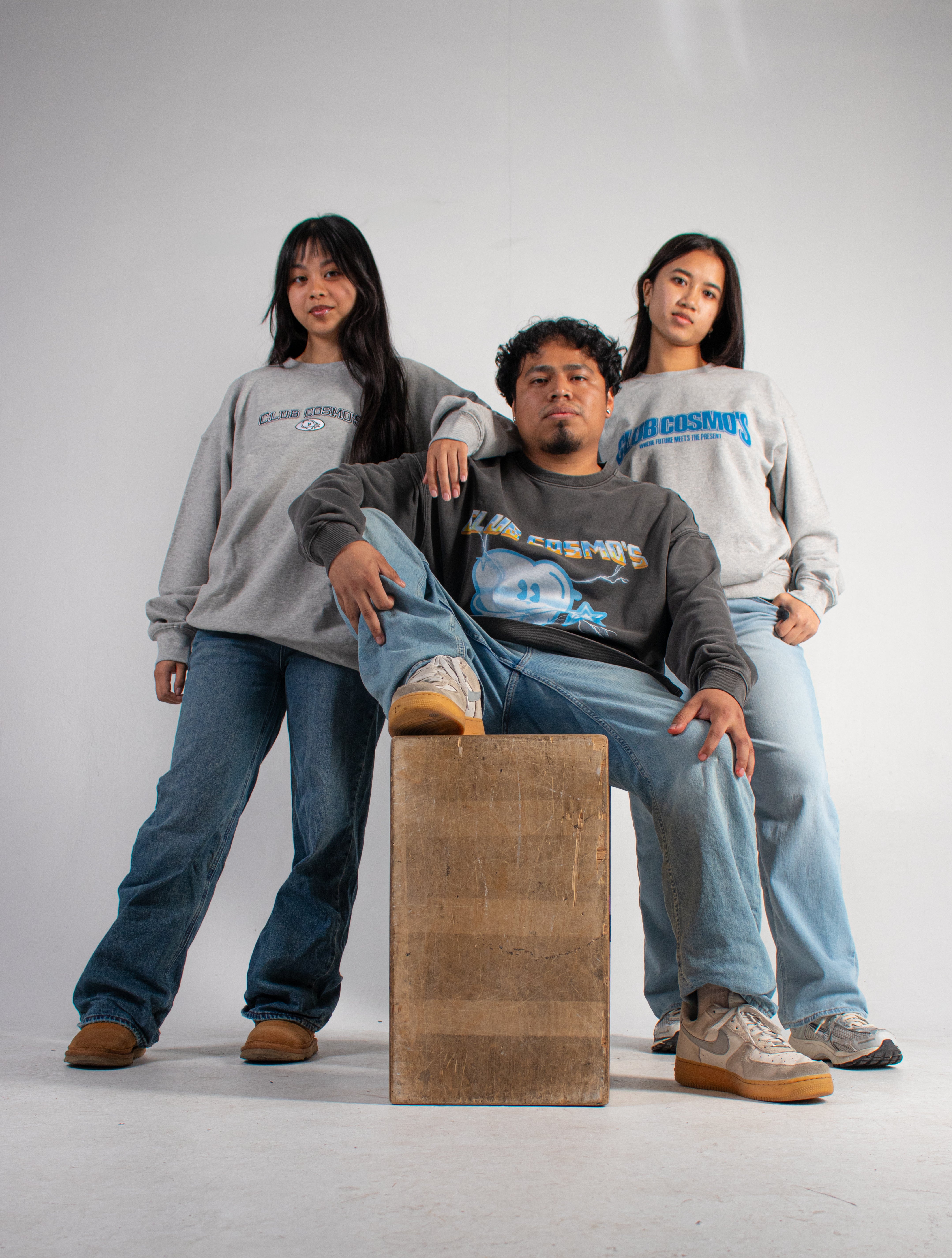 Three models wearing grey Club Cosmo's sweatshirts.